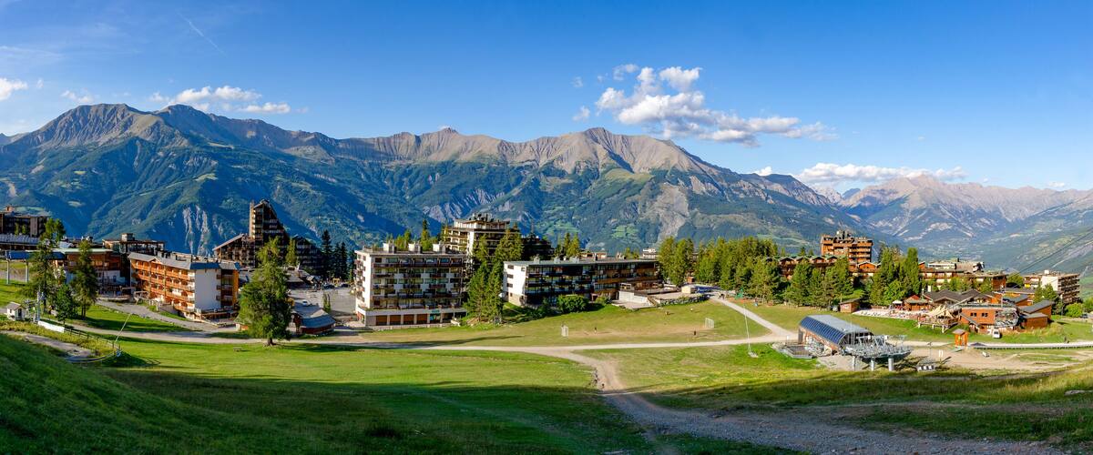 A mountainous landscape with buildings and a ski lift.
