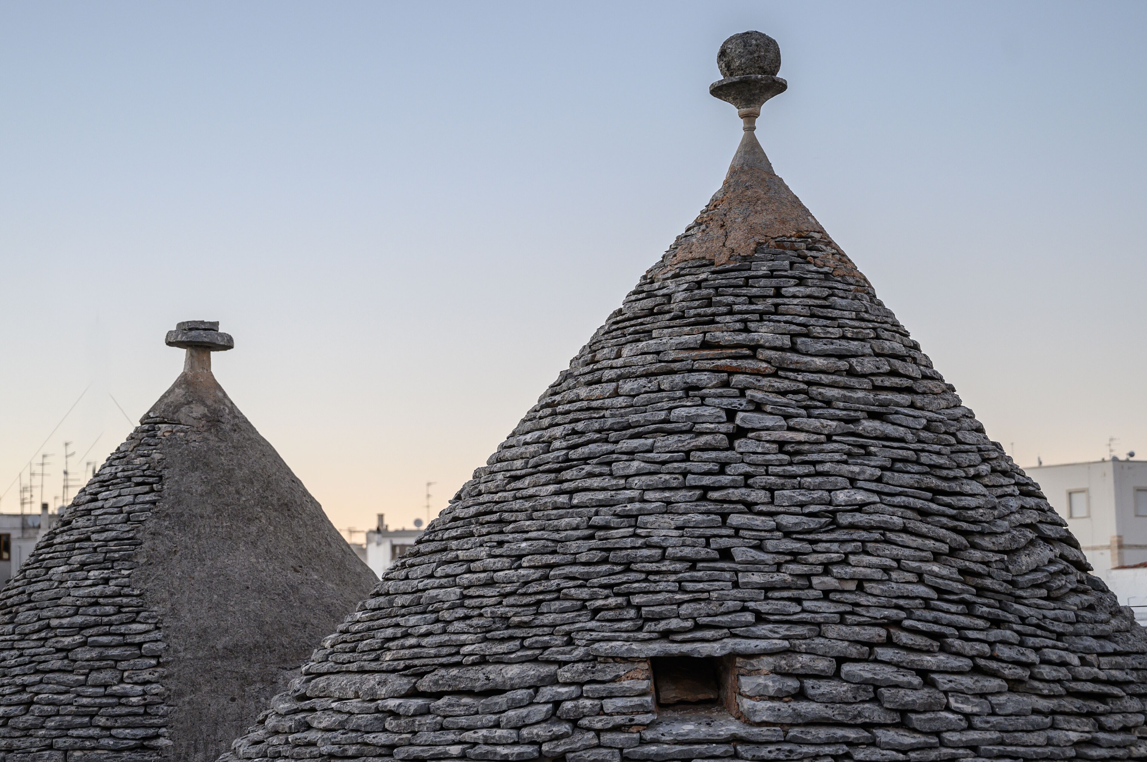 Stone-roofed buildings with conical shapes and a small window.