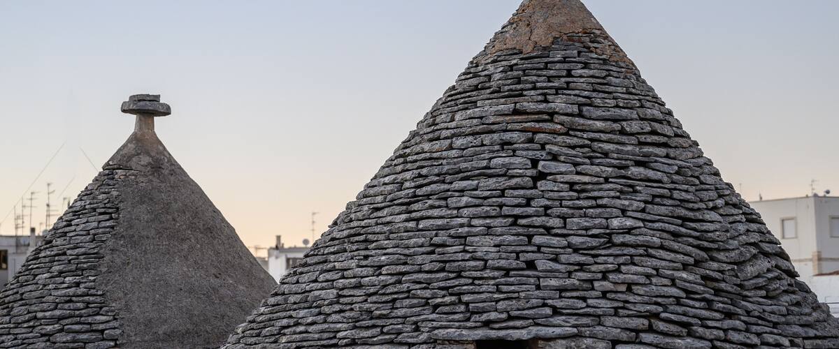 Stone-roofed buildings with conical shapes and a small window.