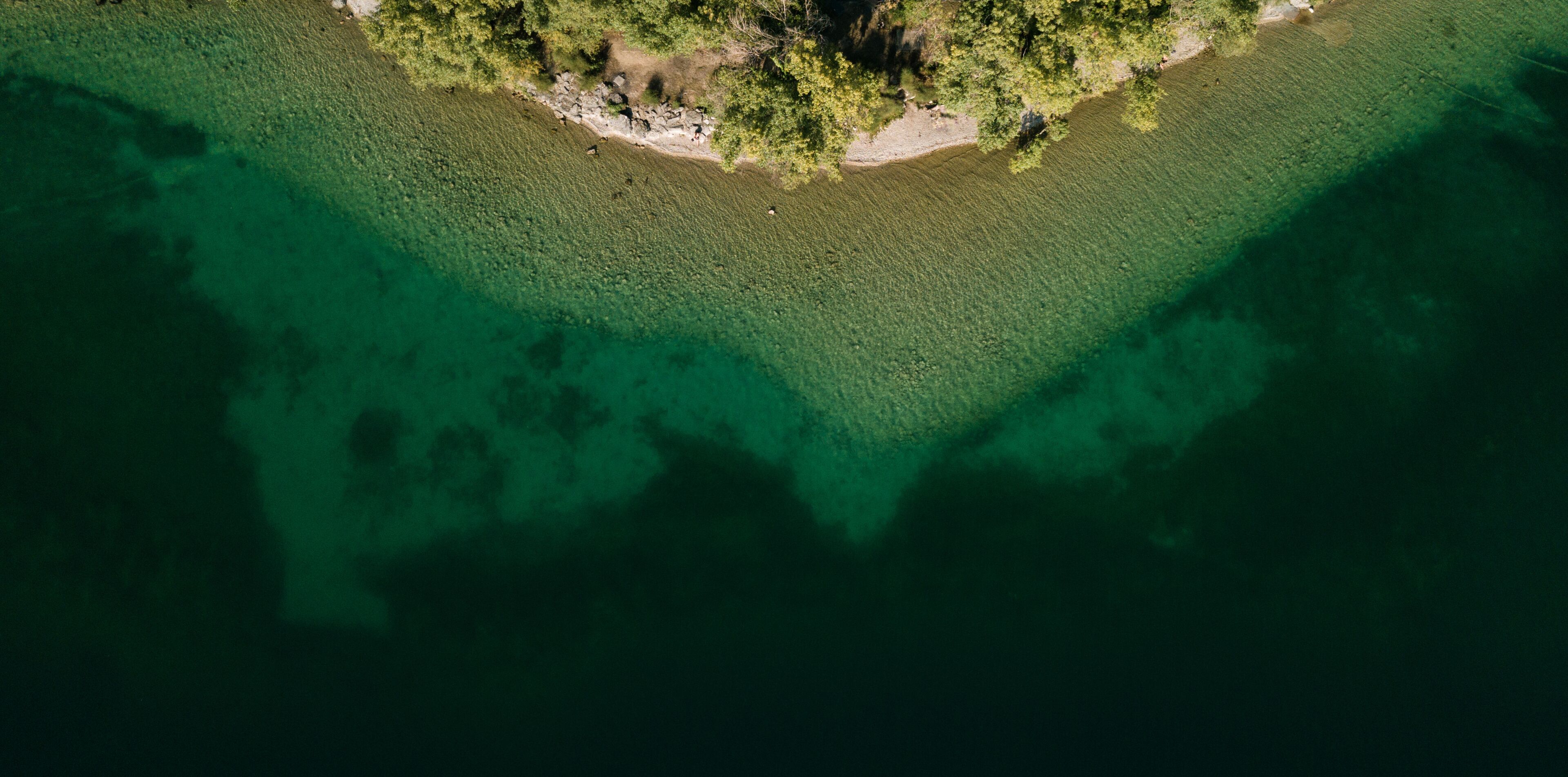 An aerial view of a small island with clear waters and dense vegetation.