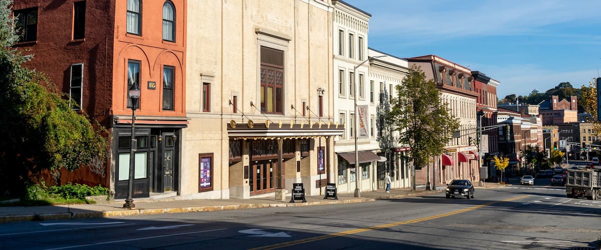 A historic street with vintage buildings, a theater, and a clear blue sky.