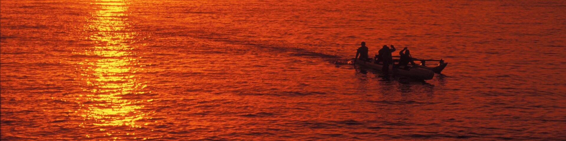 Silhouette of a group of people on a boat in the ocean, Hawaii, USA