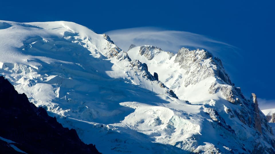 A snow-covered mountain with sharp peaks and a clear blue sky.