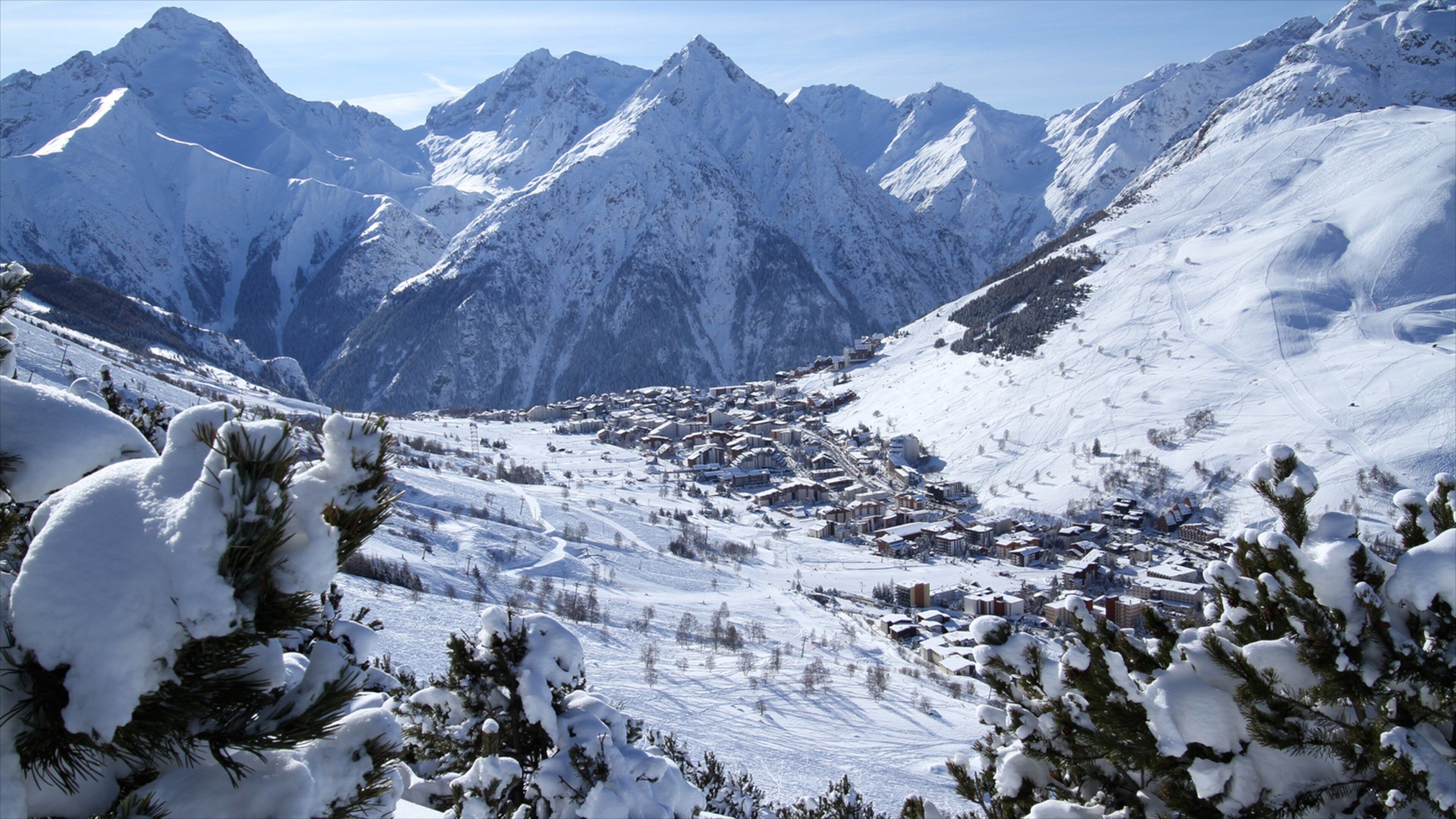 A snow-covered mountain range with a ski resort in the valley.