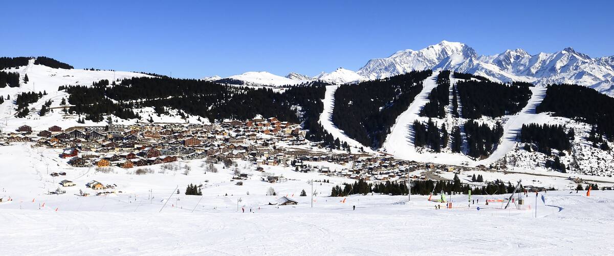 A snow-covered mountain town with ski slopes and a backdrop of snow-capped peaks.