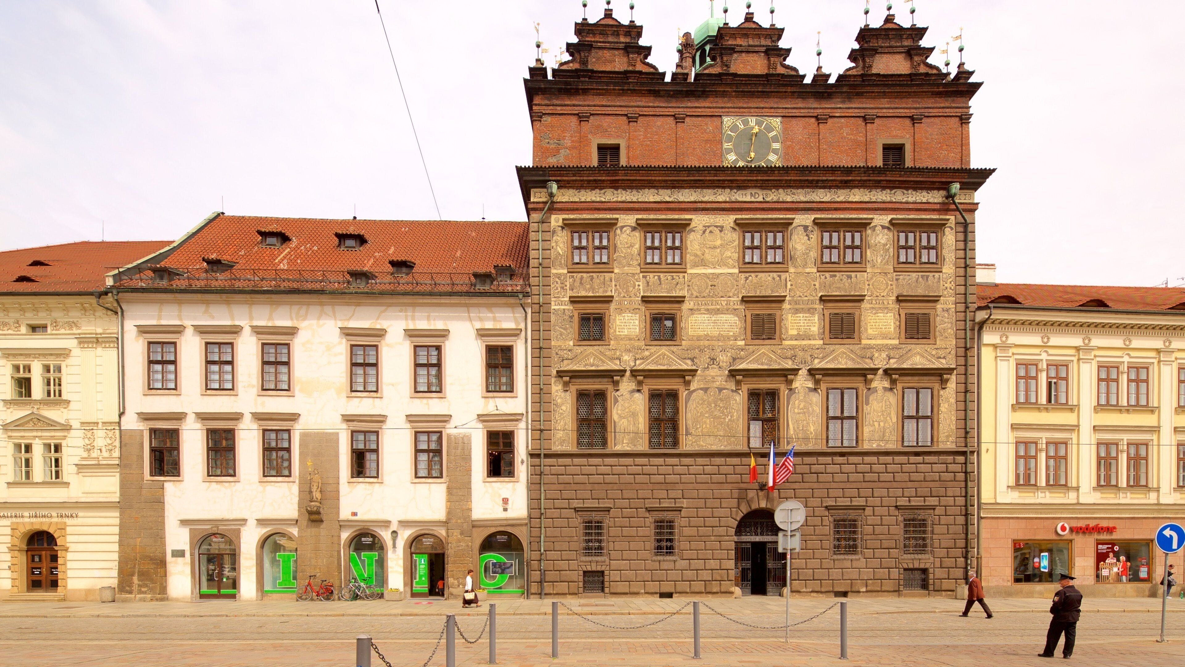 Ein historisches Gebäude mit einem Uhrturm, einem roten Dach und einem Schild mit dem Buchstaben 'N'.