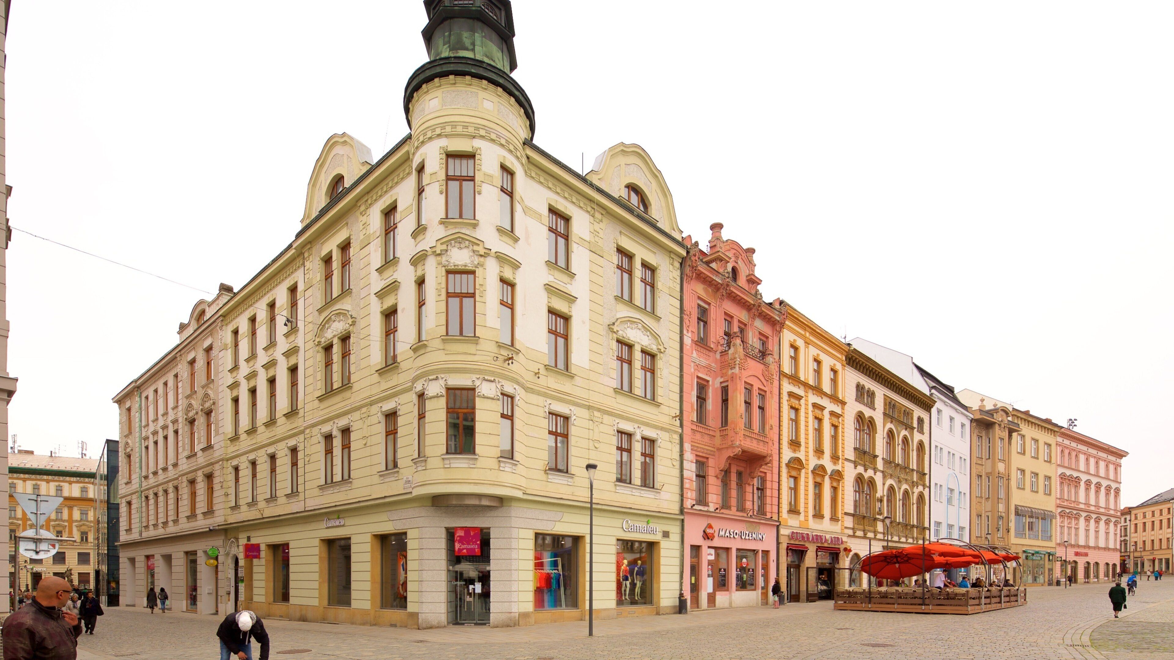 A historic building with ornate architecture, a cobblestone square, and a tram stop.