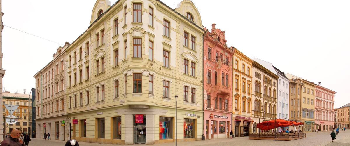 A historic building with ornate architecture, a cobblestone square, and a tram stop.