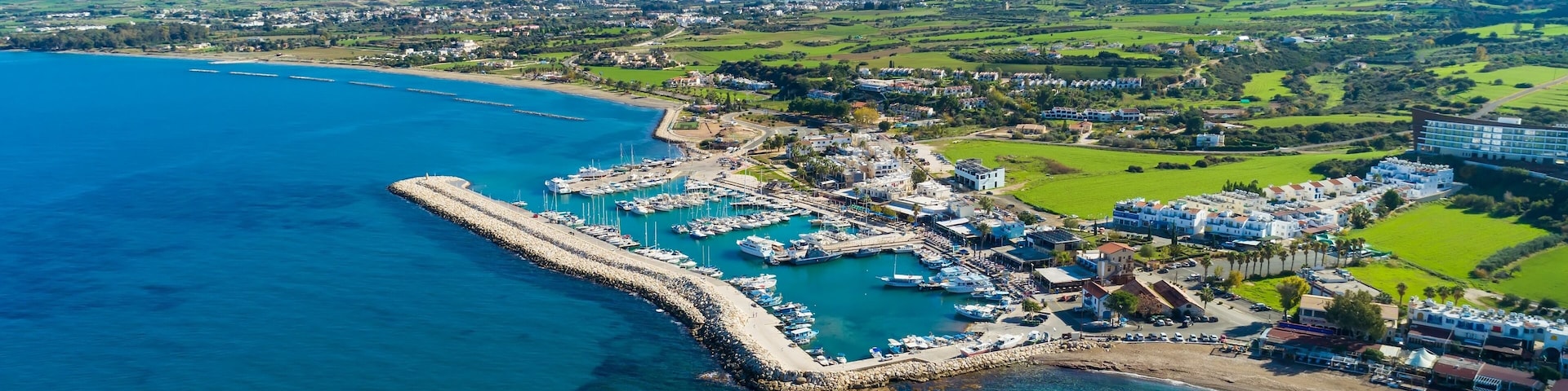 Aerial bird's eye view of Latchi port, Akamas peninsula, Polis Chrysochous, Paphos,Cyprus. Latsi harbour with boats and yachts, fish restaurant, promenade, beach tourist area and mountains from above