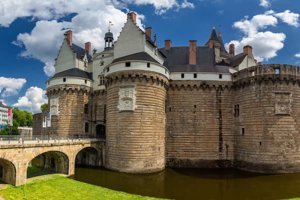 Un chĂąteau historique dotĂ© de nombreuses tours, dâun fossĂ© et dâun pont.