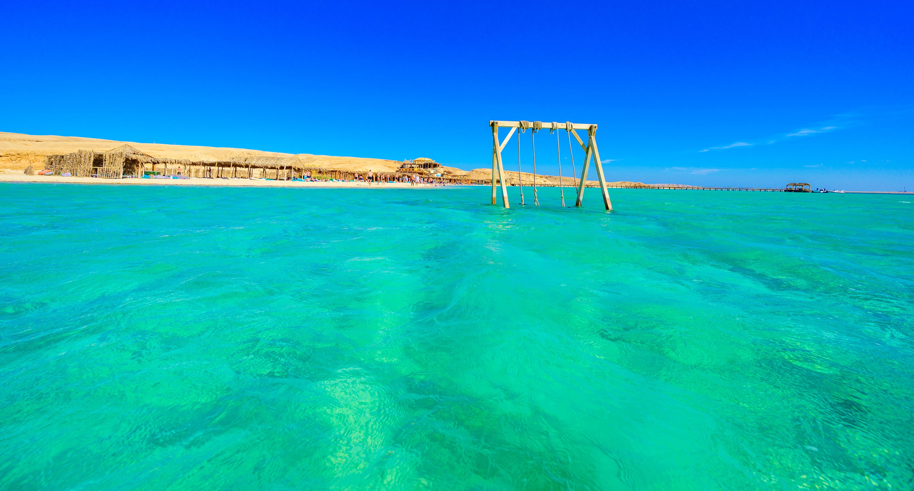 Swing in crystal clear azure water - Orange Bay Beach with white beach - paradise coastline of Giftun island, Mahmya, Hurghada, Red Sea, Egypt