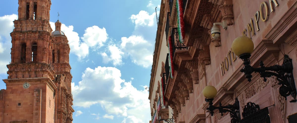 A historic building with a clock tower and a sign that reads "HOTEL EMPORIO".