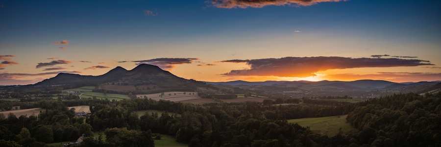Un paisaje montañoso con un atardecer.