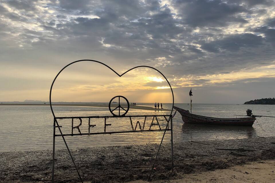 A beach scene with a boat and a heart-shaped structure with 'FREE WAY' written on it.