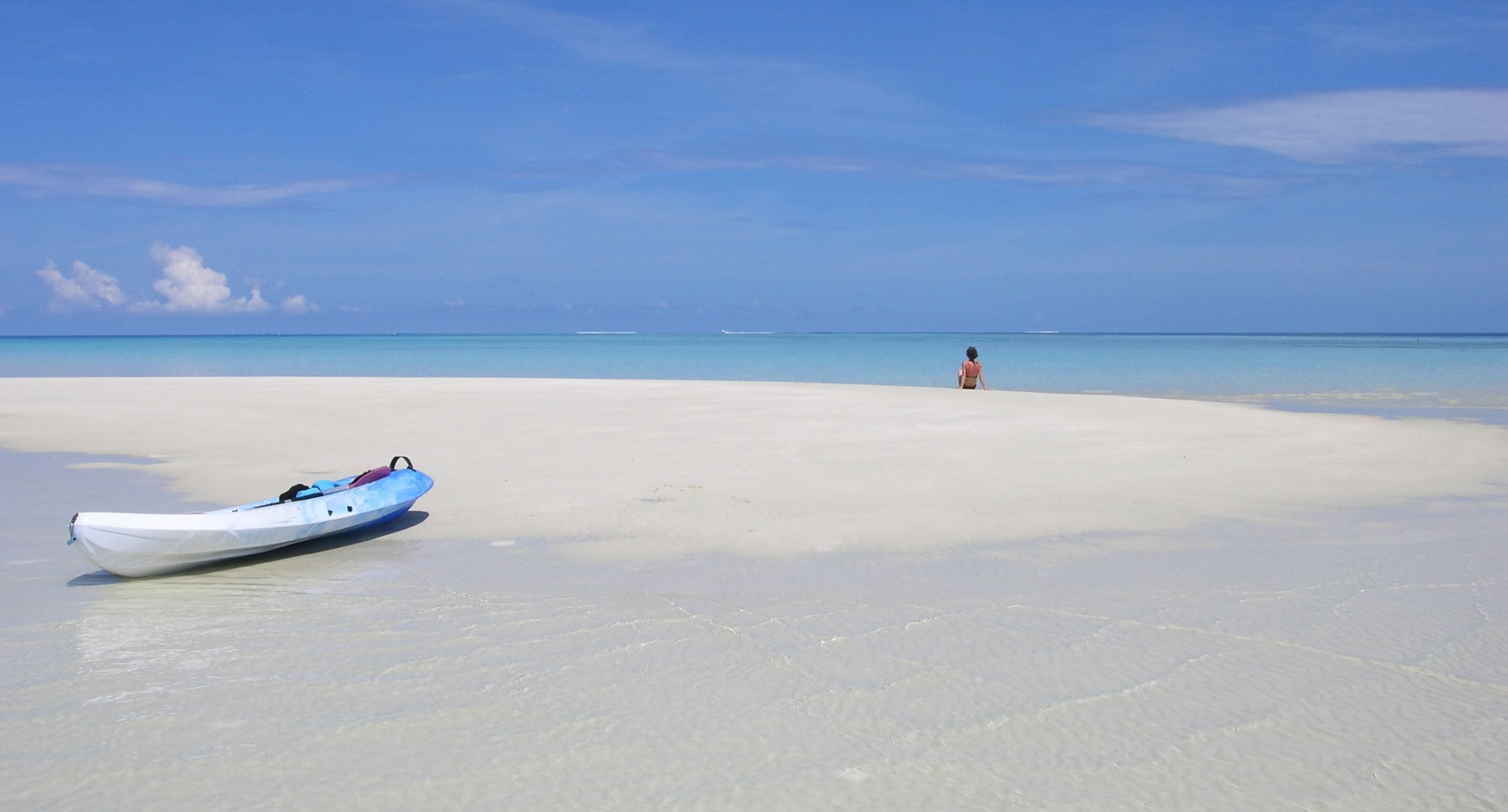 canoe kayak et femme sur banc de sable aux maldives