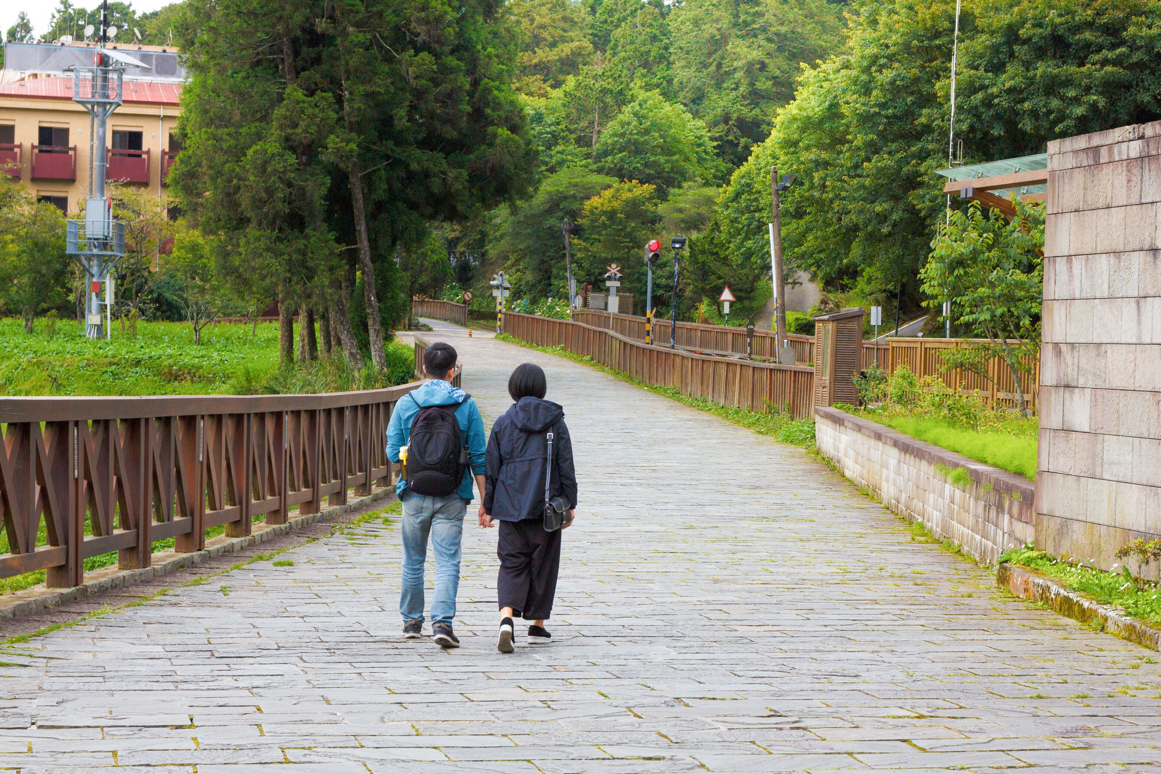 picture of couple holding hands and walking  on the road near Alishan train station. Alishan Taiwan