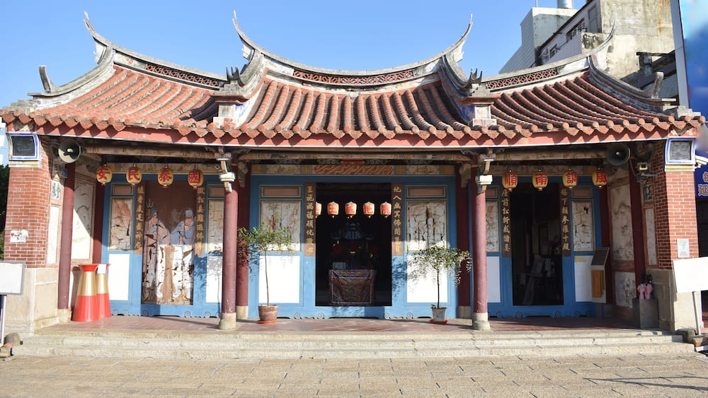 Un temple chinois traditionnel, avec ses toits couverts de tuiles rouges richement décorées et ses sculptures complexes.