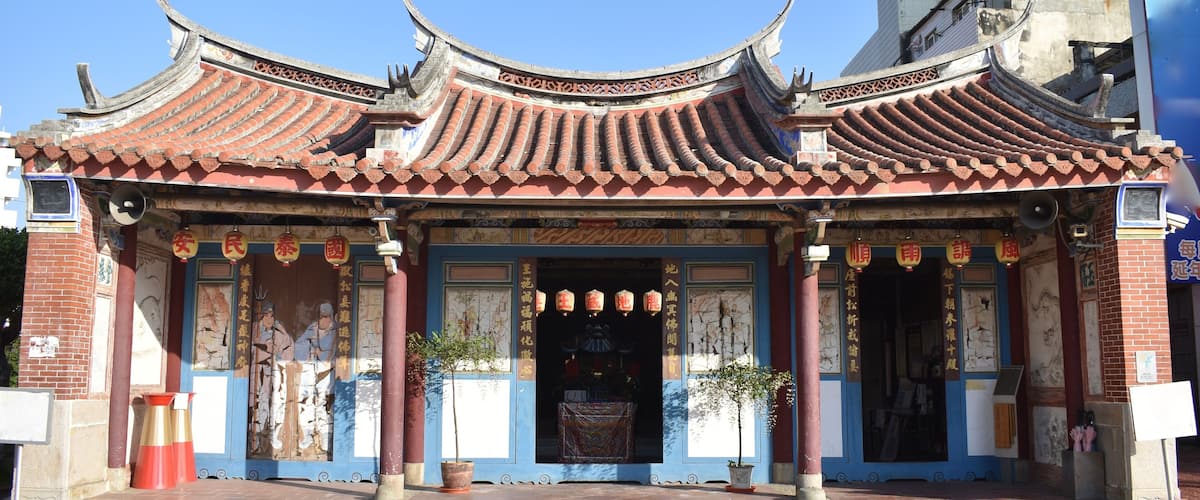 A traditional Chinese temple with ornate red-tiled roofs and intricate carvings.