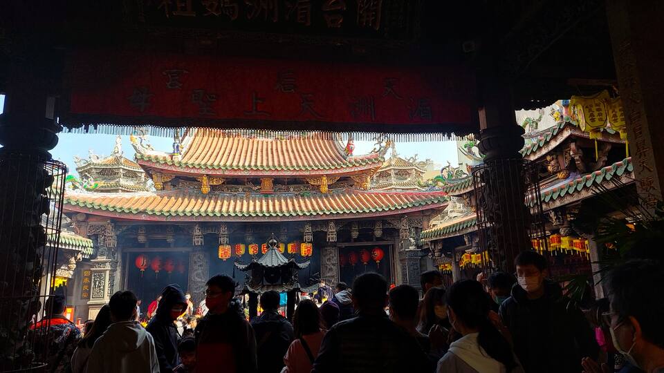 A traditional Chinese temple with ornate architecture and red banners.