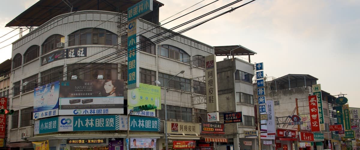 A street with multiple commercial buildings, including a pharmacy and a hair salon.