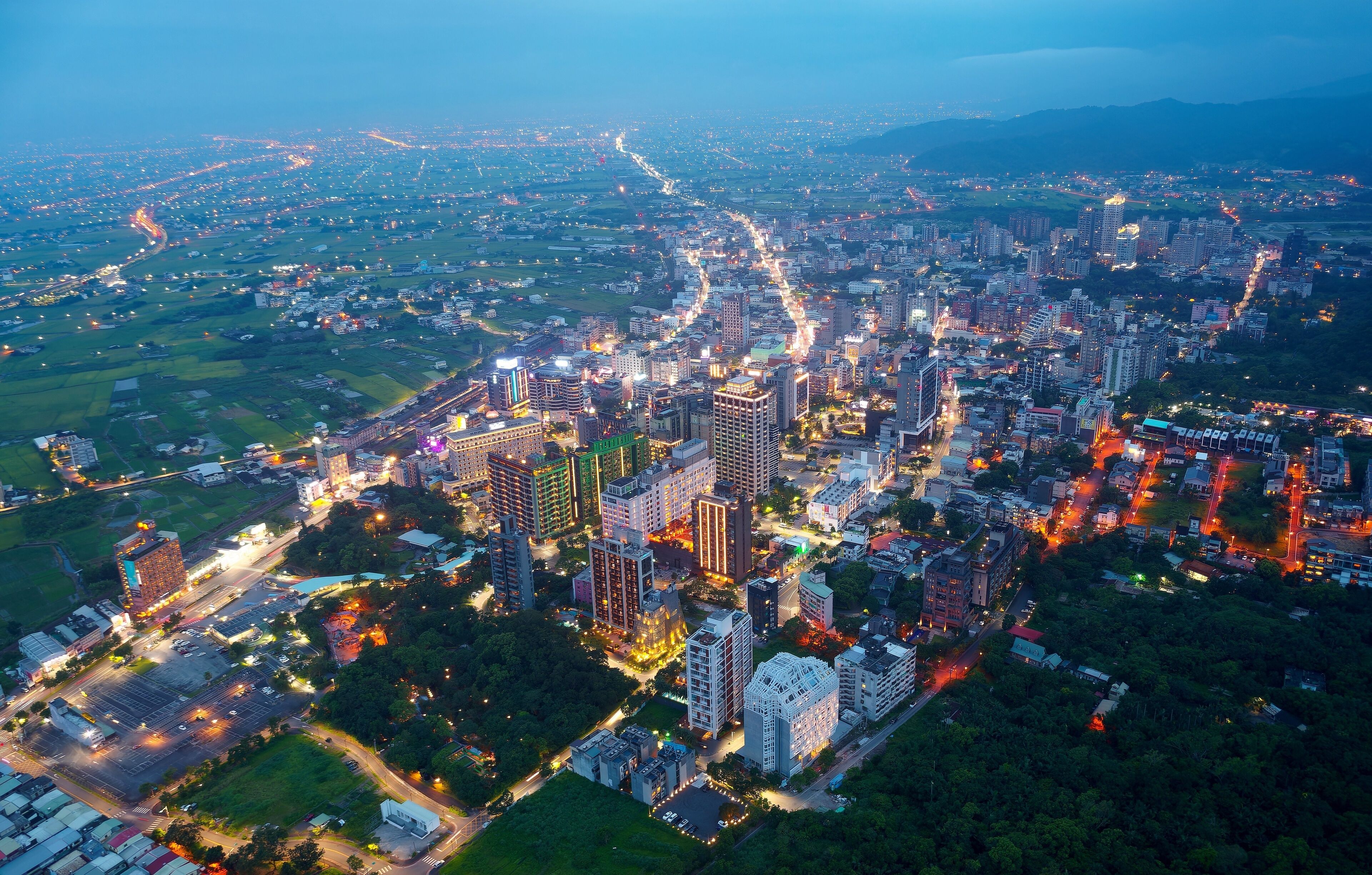 Aerial view of the high-rise buildings and hotels at blue dusk in Downtown Jiaoxi, which is a famous hot spring resort and tourist destination in Yilan County, Taiwan, on a cloudy moody evening