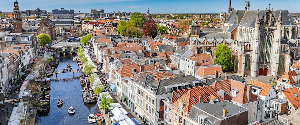A canal lined with historic buildings, a prominent church, and a bridge.