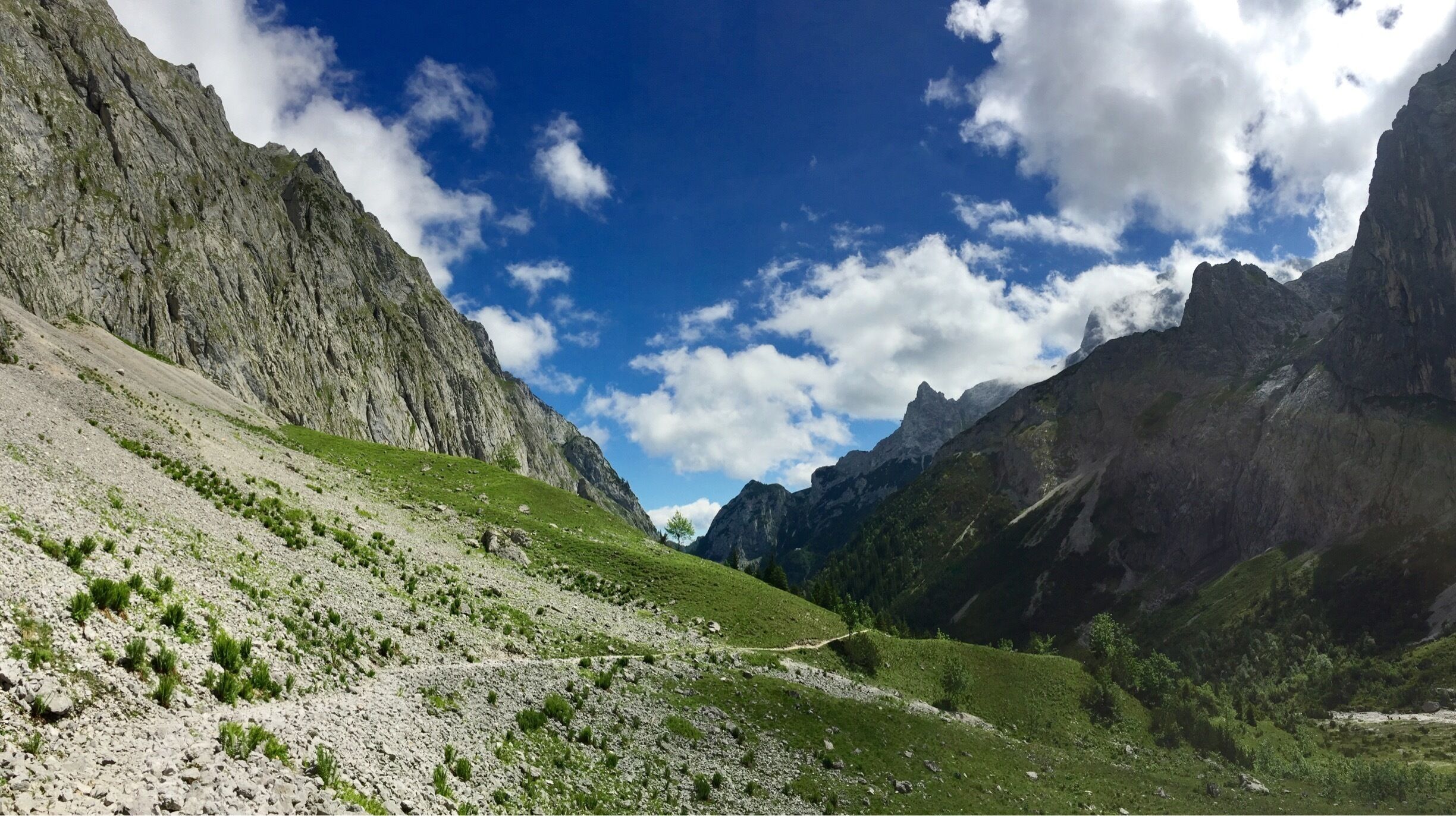 A mountainous landscape with rocky cliffs and a clear blue sky.
