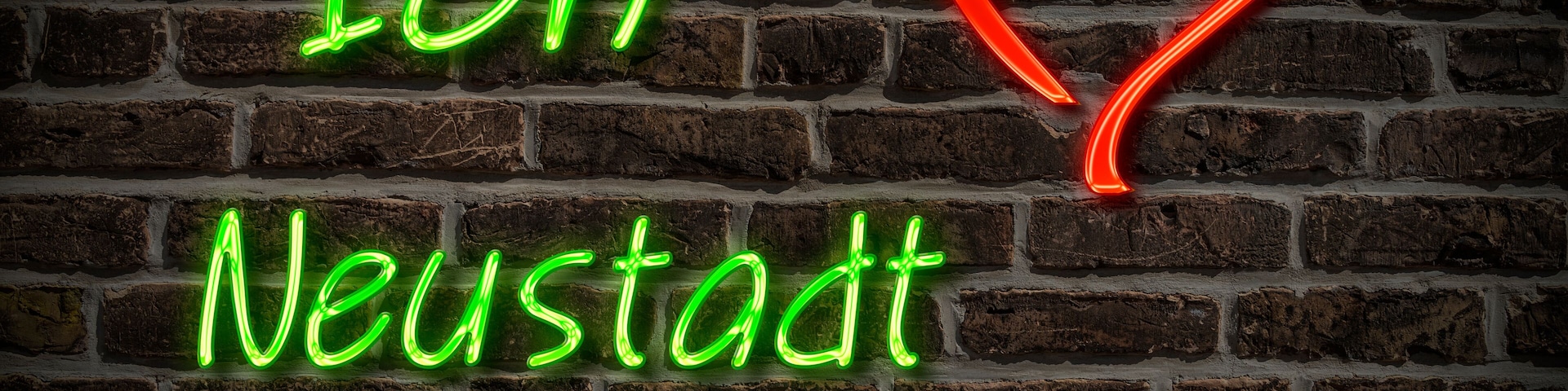 A neon sign with the text 'Ich Neustadt an der Donau' on a brick wall.