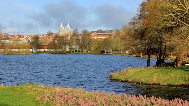Um rio calmo com um castelo ao fundo e árvores de outono ao longo das margens.