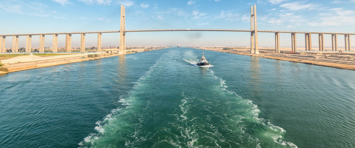 A bridge over a river with a boat in the water.