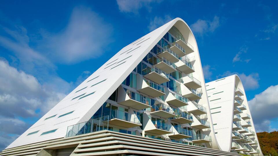 A modern architectural building with a curved facade and multiple balconies.