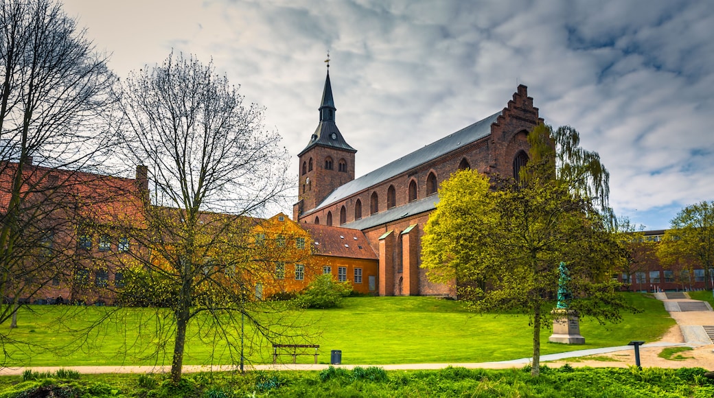 Odense, Denmark - April 29, 2017: Cathedral of Saint Canute and Statue of Hans C Andersen