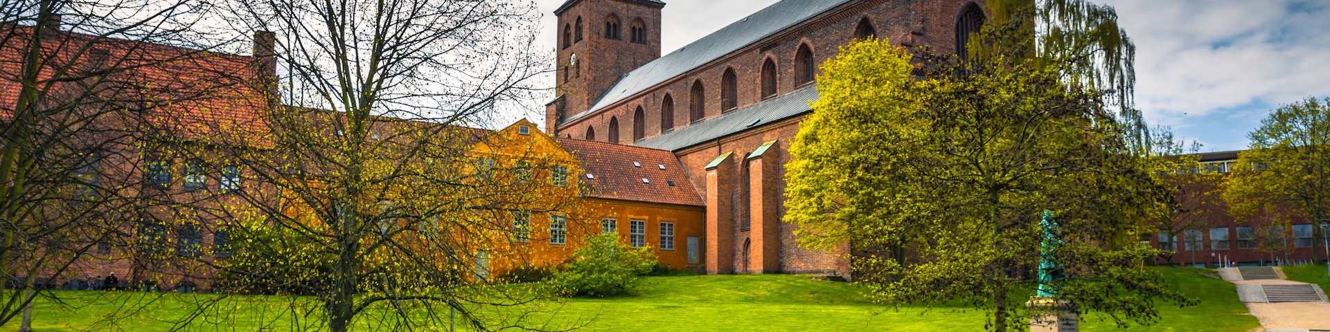Odense, Denmark - April 29, 2017: Cathedral of Saint Canute and Statue of Hans C Andersen