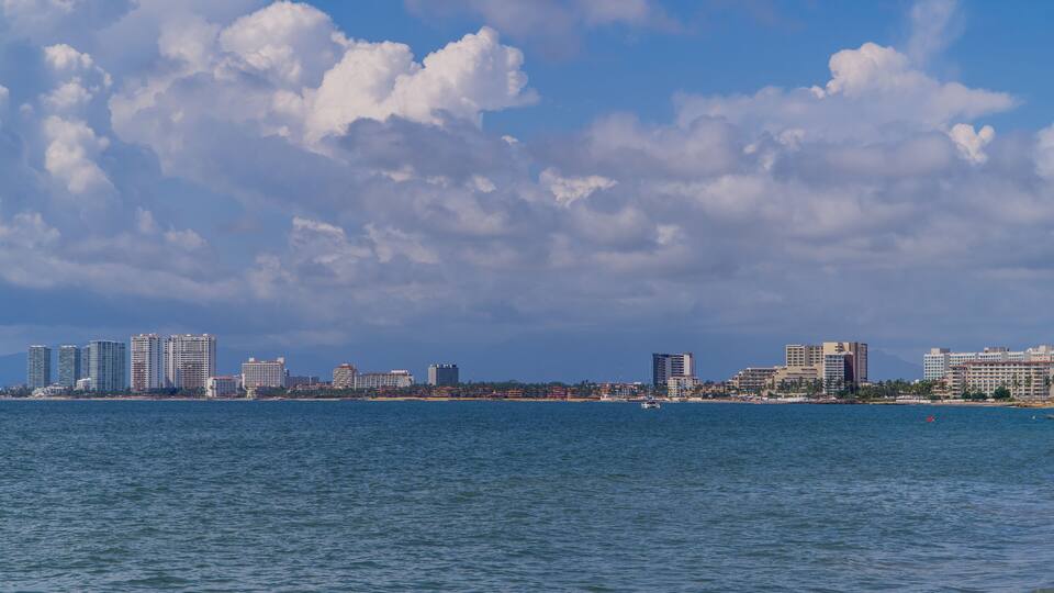 A coastal cityscape with a clear sky and calm sea.