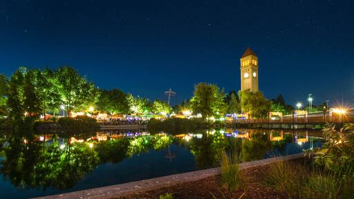 The Spokane Washington clocktower in Riverfront Park shines above the Spokane River during a busy festival in Riverfront Park, in Spokane Washington, USA