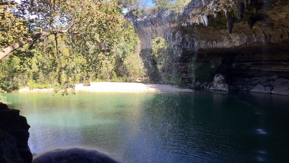 A serene lake surrounded by cliffs and trees.