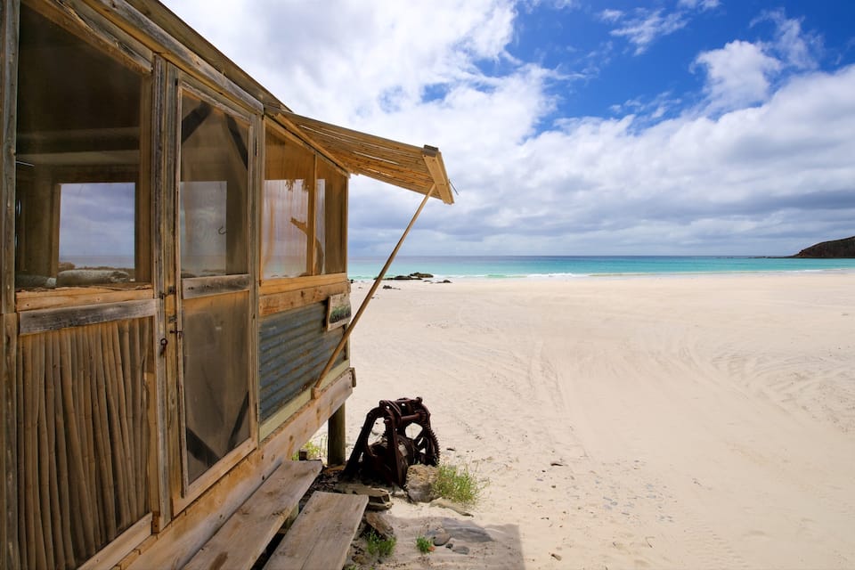 A wooden structure with a beach in the background.