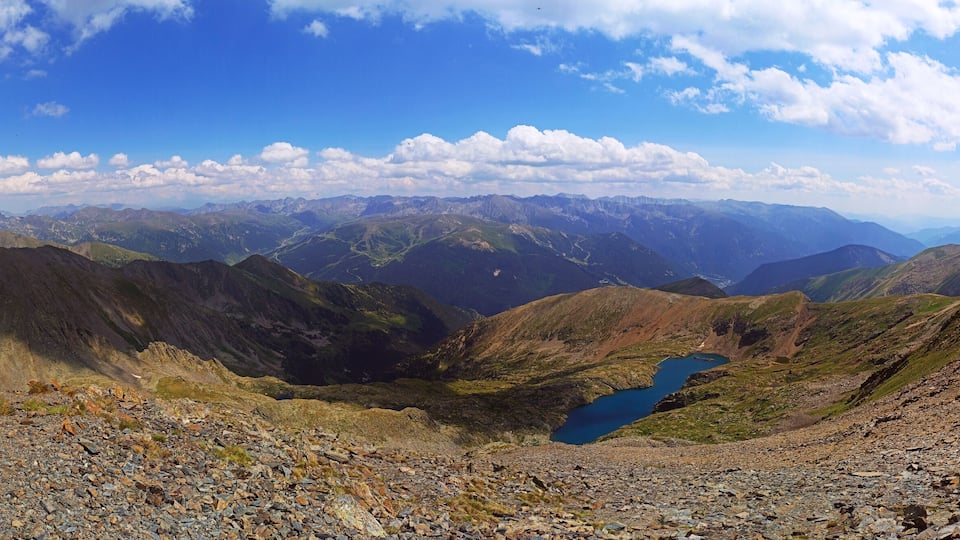 A mountain landscape with rocky terrain and a small lake.