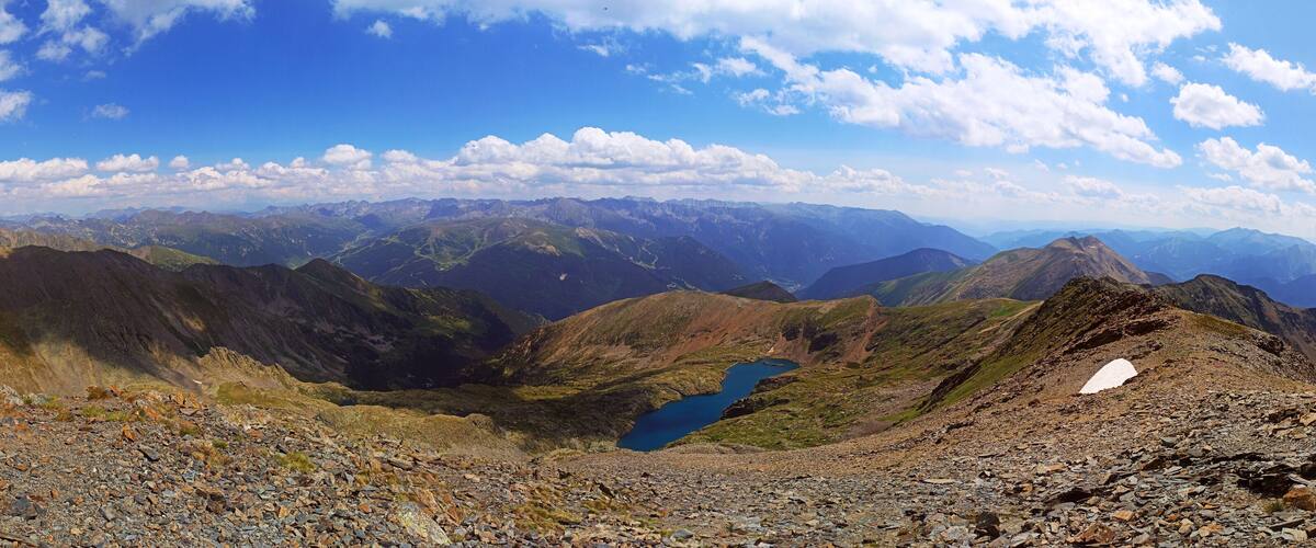 A mountain landscape with rocky terrain and a small lake.