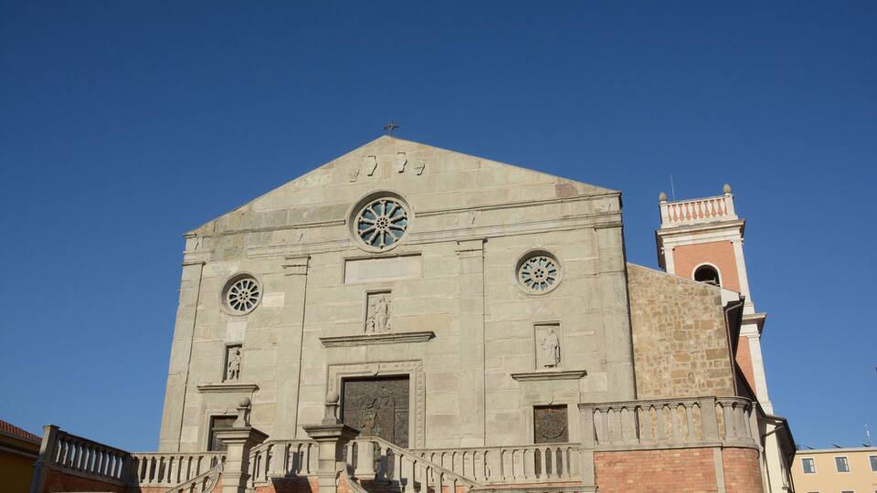 A large church with a bell tower and two large circular windows.