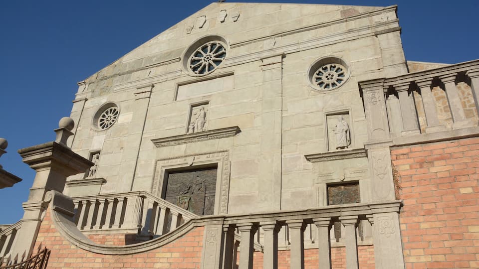 A historic building with a prominent clock tower, arched windows, and detailed stonework.