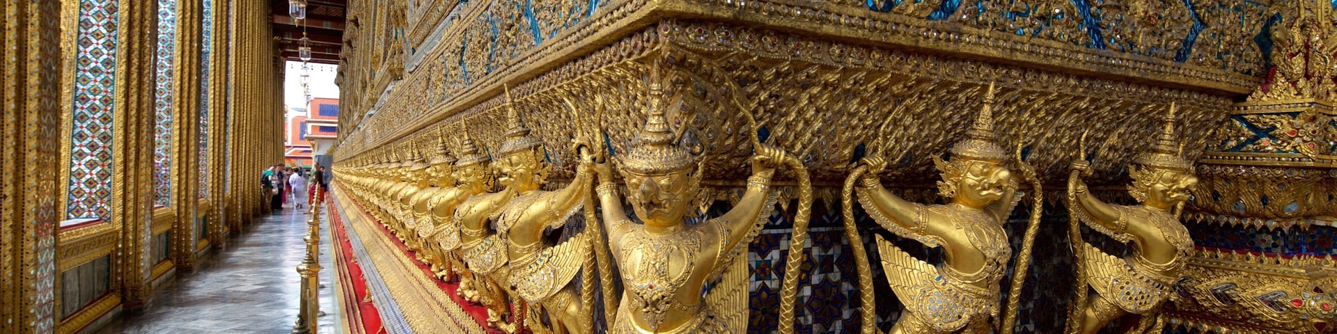 Una estatua dorada con detalles intrincados y un pedestal rojo.
