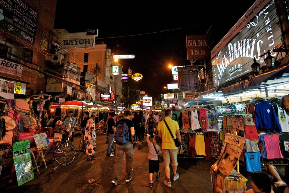 Un marché de rue animé, de nuit, avec de nombreux commerces et étals.