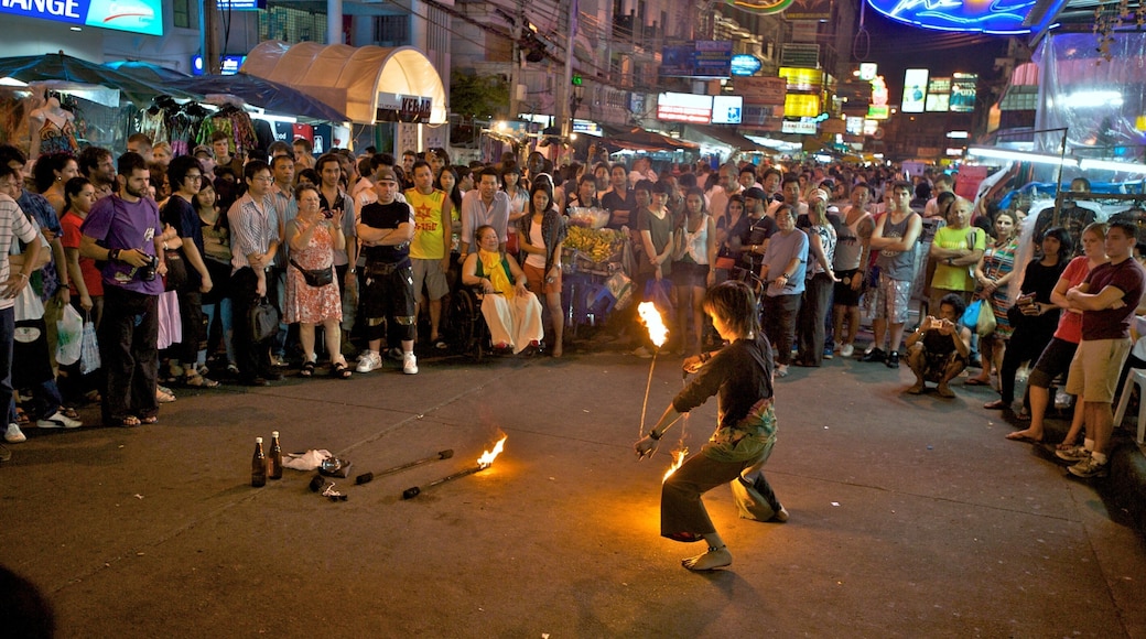 Crowds gather on Khaosan Road in Bangkok to watch street performer showcase fire skills at night
