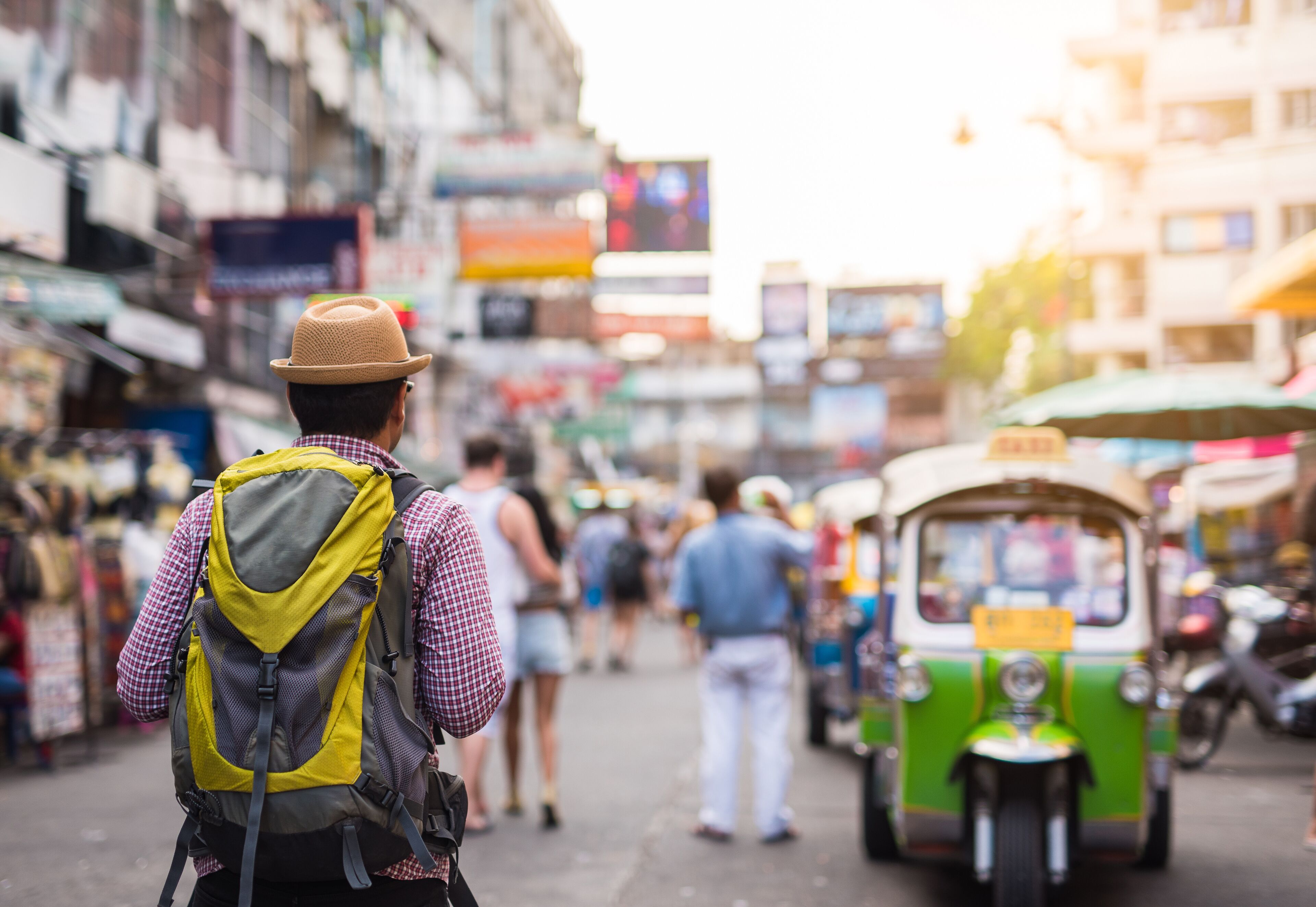 Young asian traveller man walking in Khaosan Road walking street in bangkok thailand on vacation time.