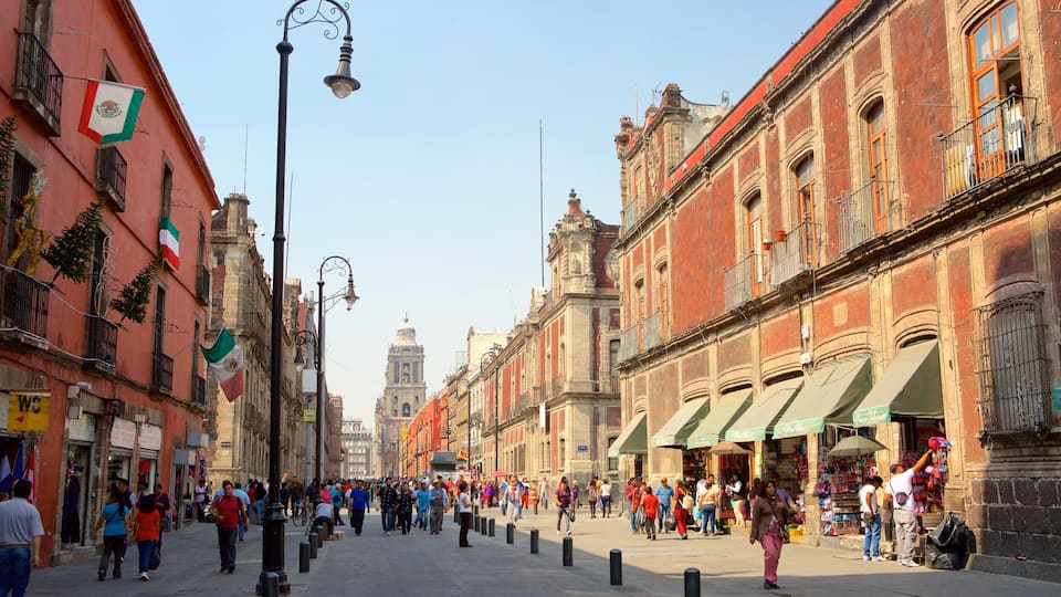 A bustling street with historic buildings, flags, and pedestrians.