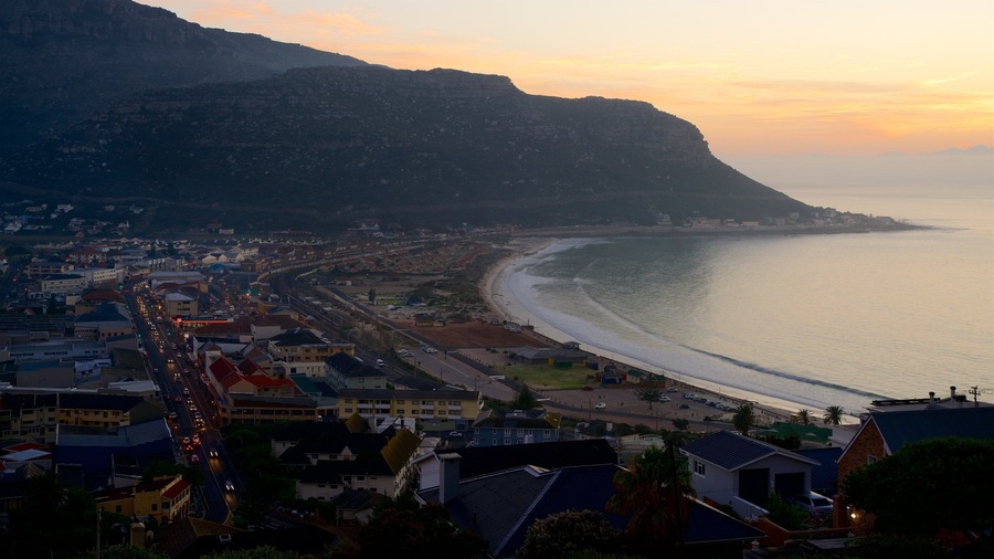 A coastal cityscape with a beach, urban buildings, and a mountain in the background.