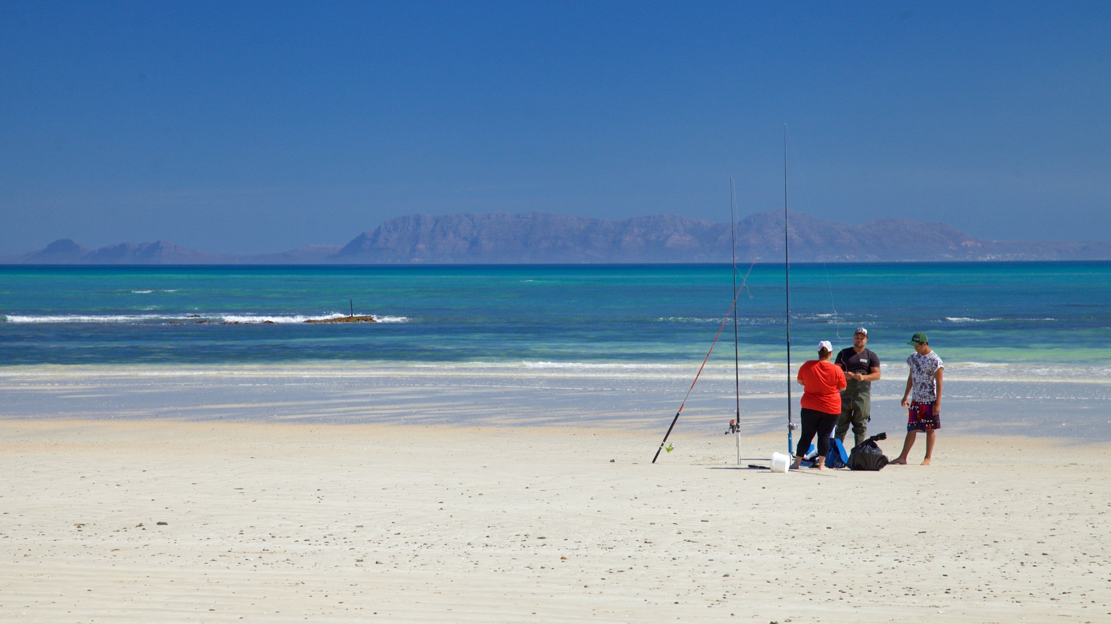 Strand featuring fishing and a beach as well as a small group of people