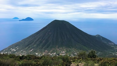 A large volcano with a small settlement at its base.