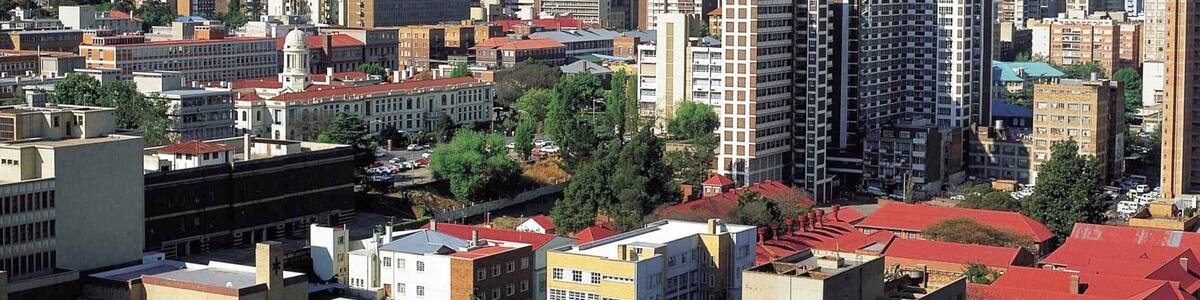 A cityscape with a prominent tower, various high-rise buildings, and a mix of residential and commercial structures.